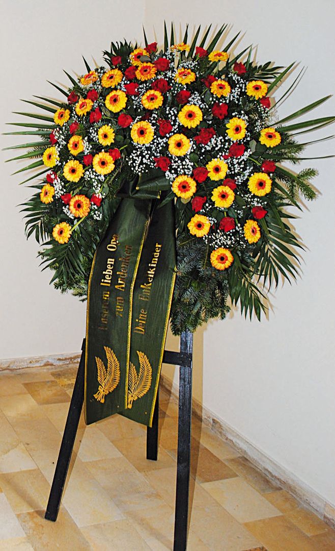 K 6 - dottergelbe Gerbera mit dunkler Mitte, rote Rosen, dazwischen Schleierkraut